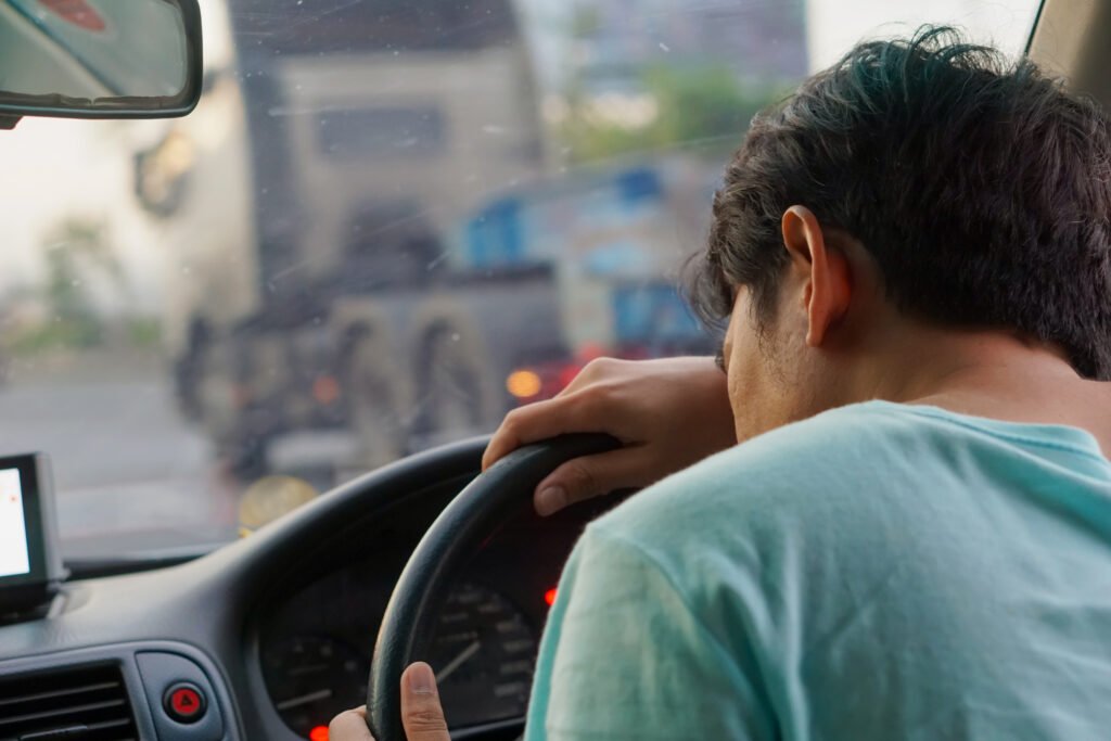 Motorista de frota leve recebendo alerta de fadiga no painel em via urbana movimentada.